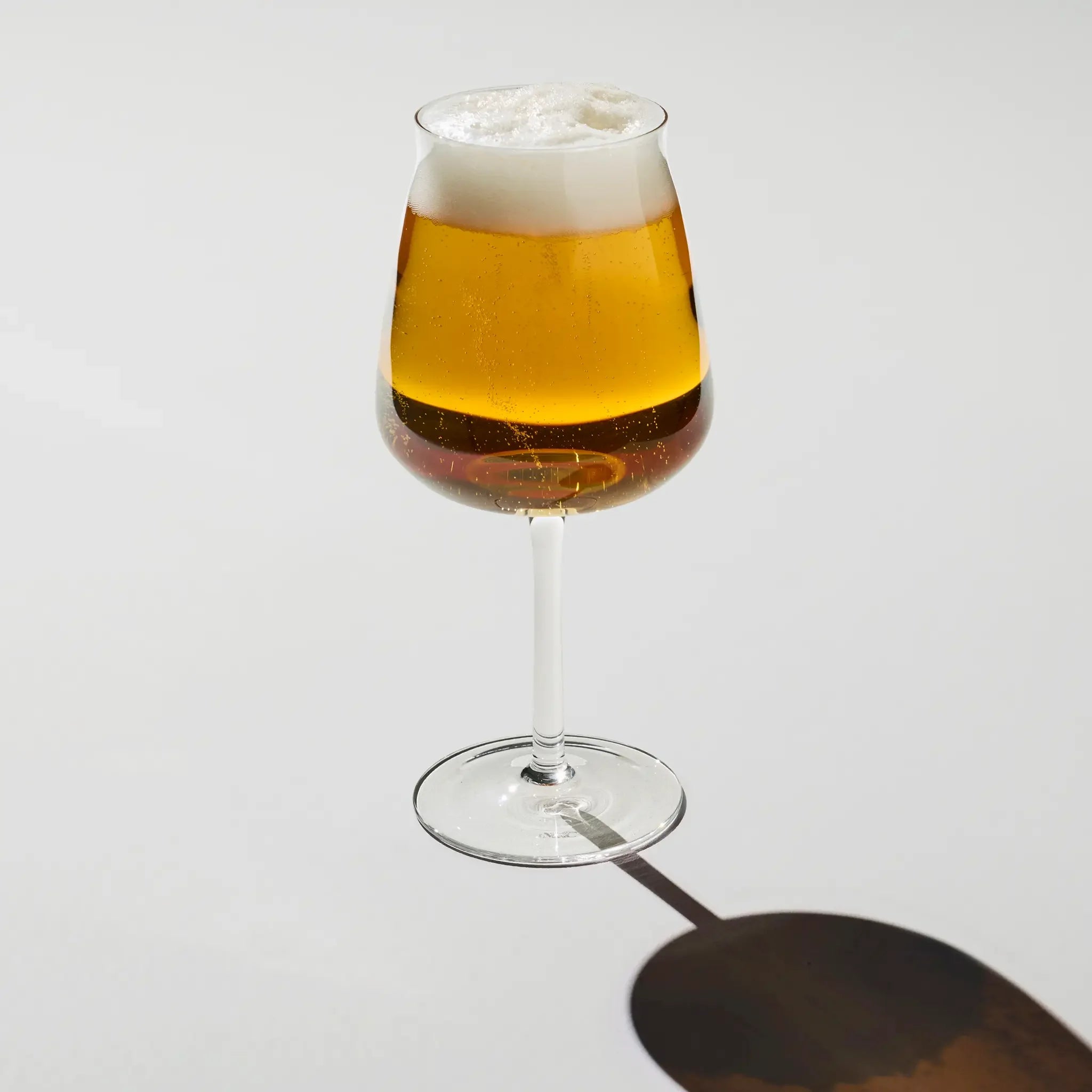 Brewer’s Tower Glass filled with golden beer – slender glass with foamy head, highlighting aroma and bubbles for a refined drinking experience.
