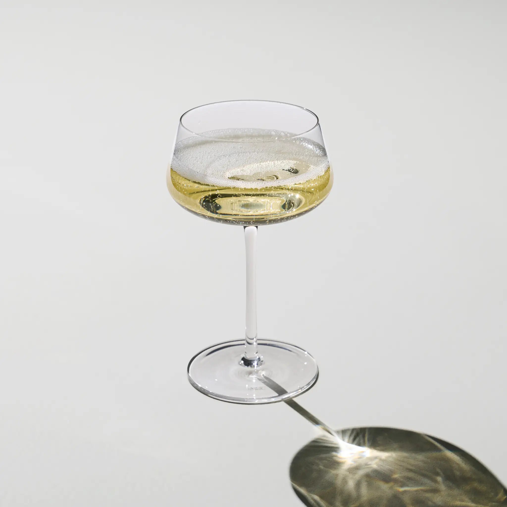 Beyond Bubbly Coupe filled with champagne – broad coupe bowl and fine bubbles rising, perfect for luxury celebrations and vintage pours.