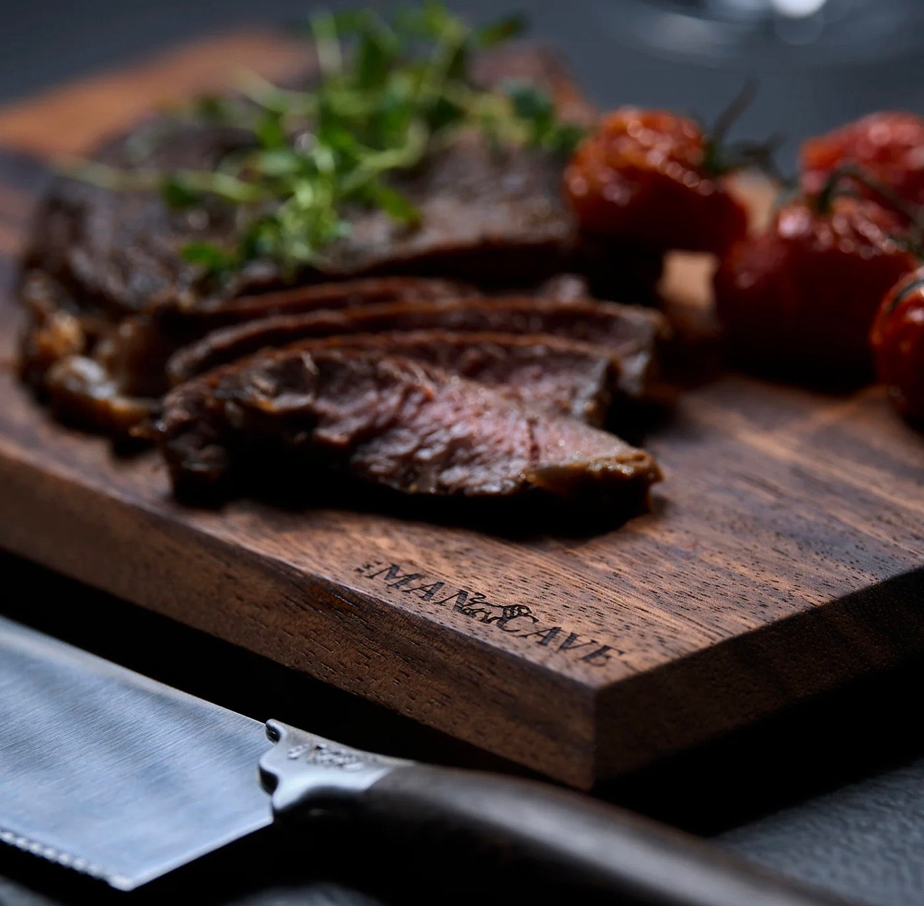 Sliced beef on a wooden cutting board with a knife from The Mancave