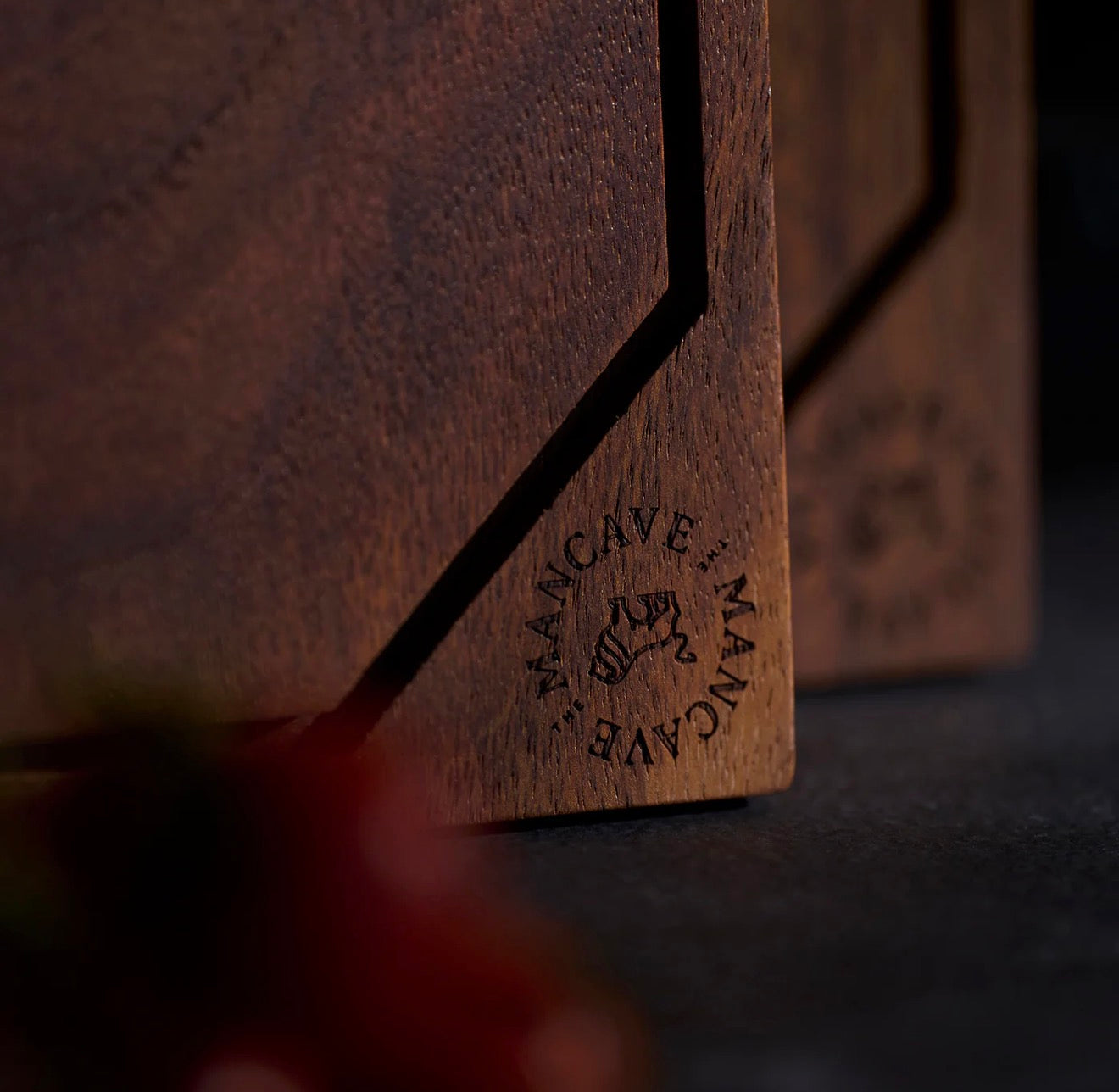 Close-up of a wooden product with 'Mancave' branding on a dark background The Chef´s Cutting Board